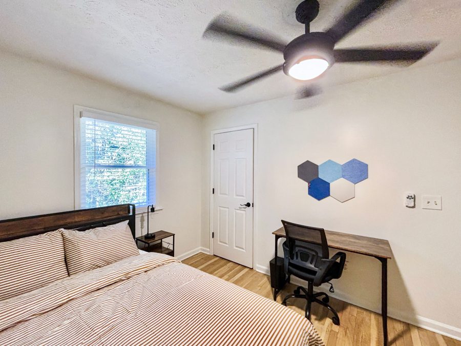 Furnished bedroom with a bed, desk, and window at The Candace House